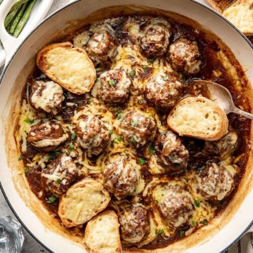 Overhead view of a skillet of French Onion Meatballs topped with melted cheese