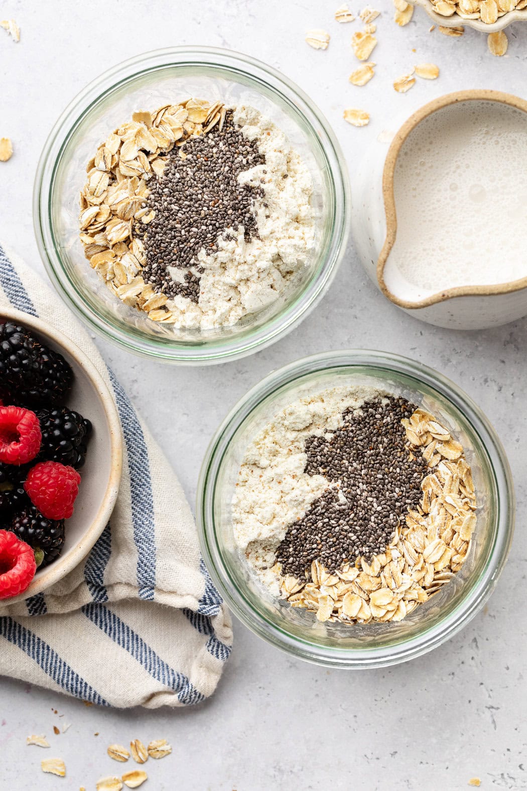 Overhead view of two glass jars with dry ingredients for Protein Overnight Oats. 