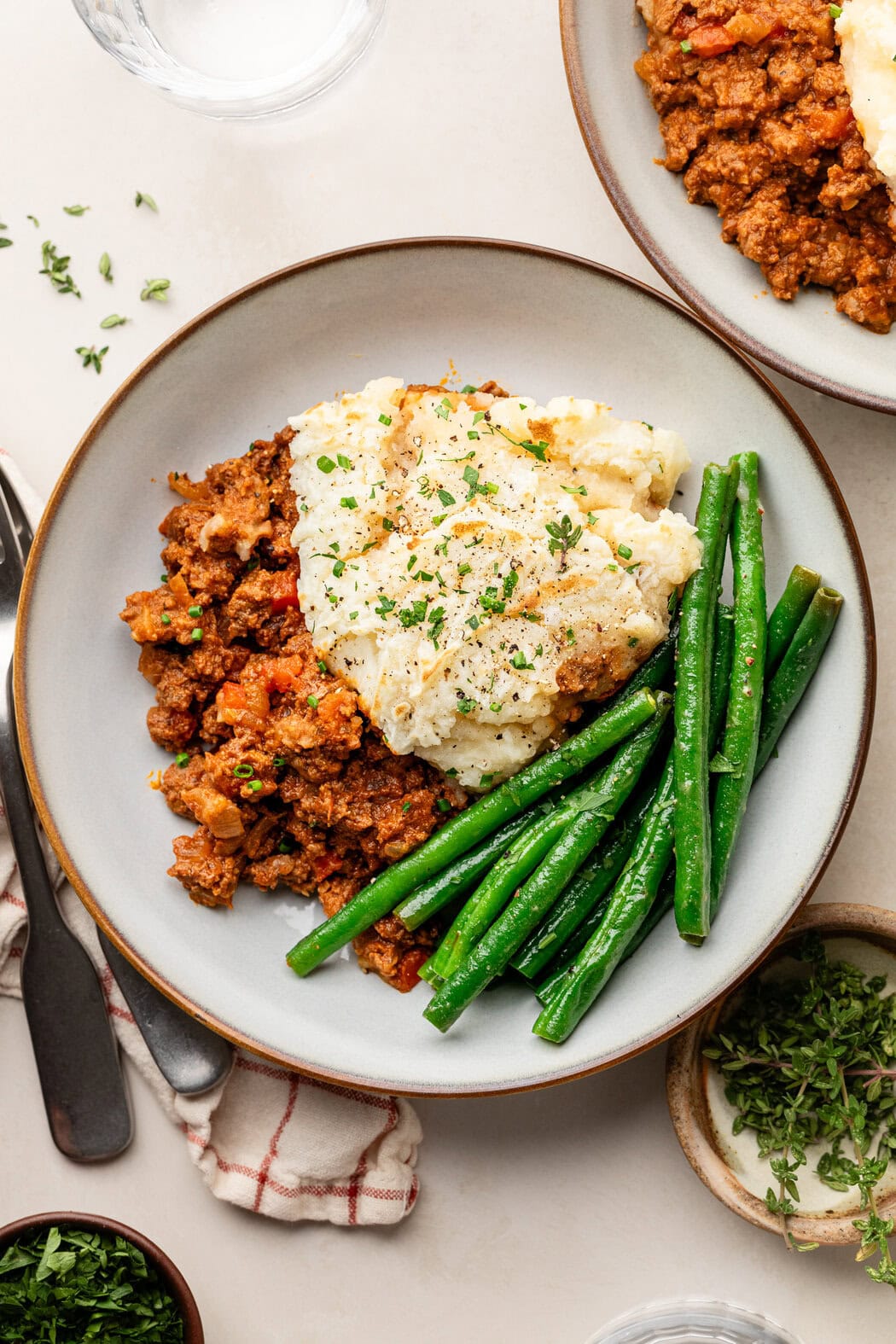 Overhead view of a plate of Sloppy Joe Casserole with green beans on the side. 