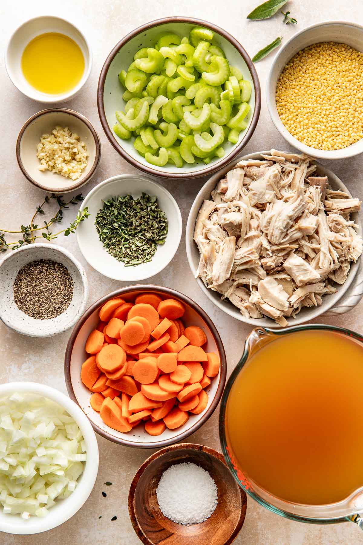 Overhead view of a variety of ingredients for Turkey Soup including celery and carrots in different sized bowls. 