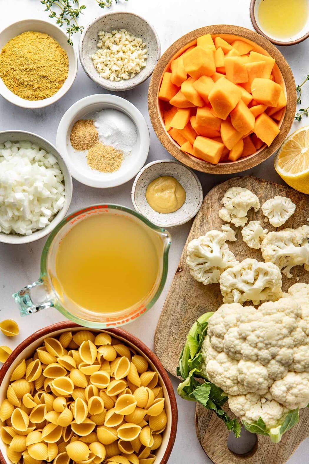 Overhead view of a variety of ingredients for Butternut Squash Mac And Cheese in different sized bowls.