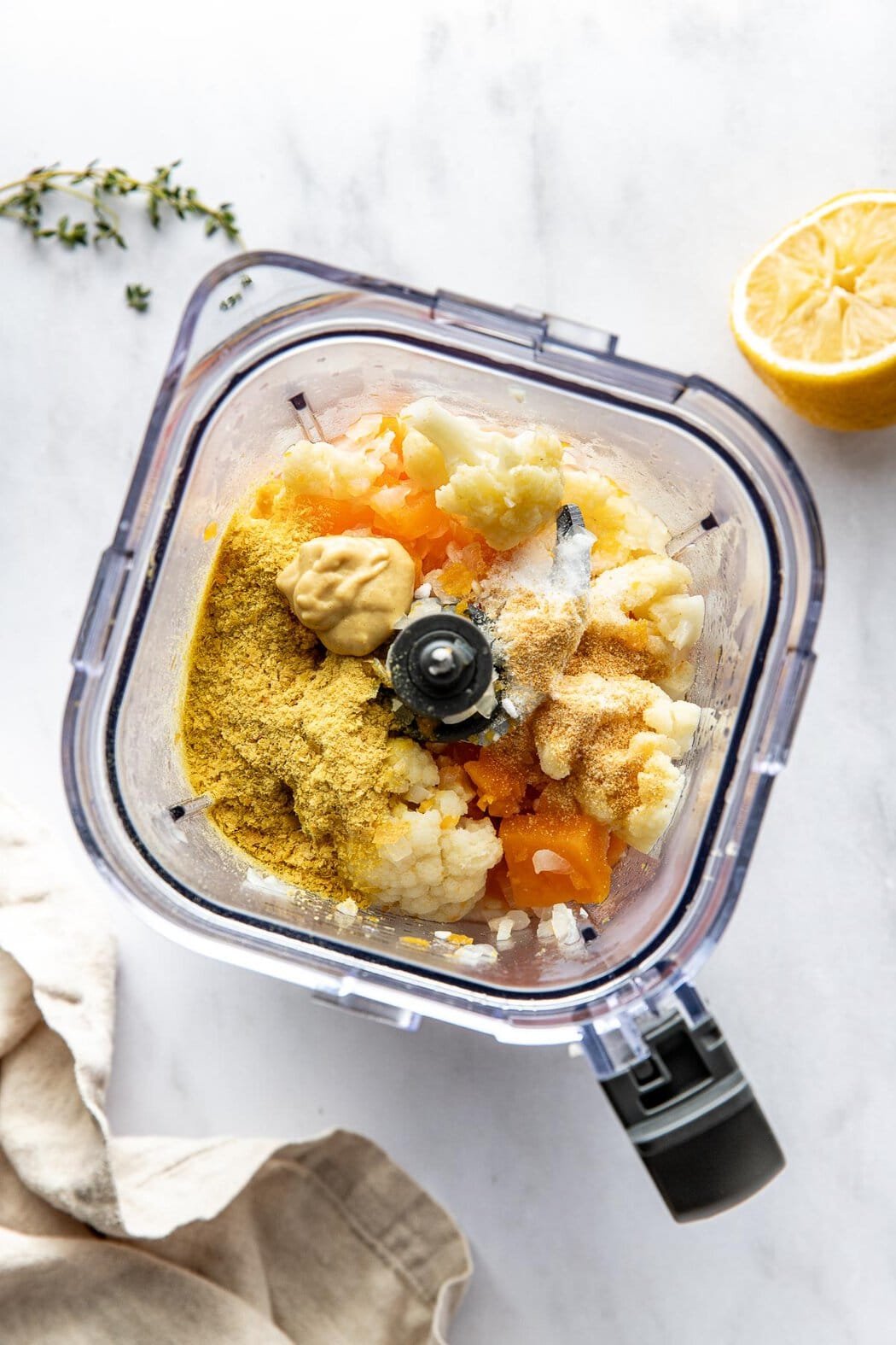 Overhead view of a blender filled with ingredients for Butternut Squash Mac and Cheese ready for blending.