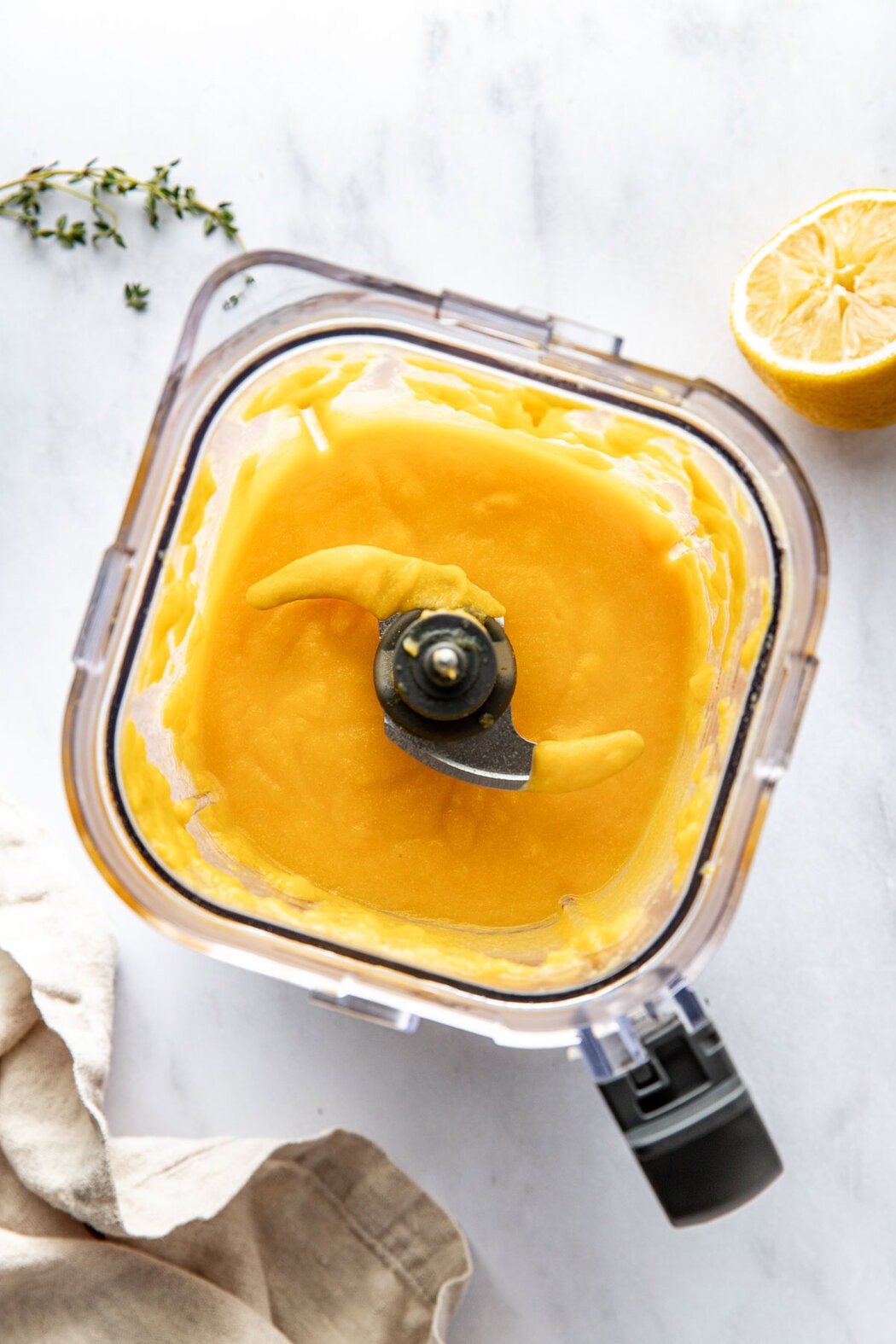 Overhead view of a blender filled with a smooth butternut squash creamy sauce.