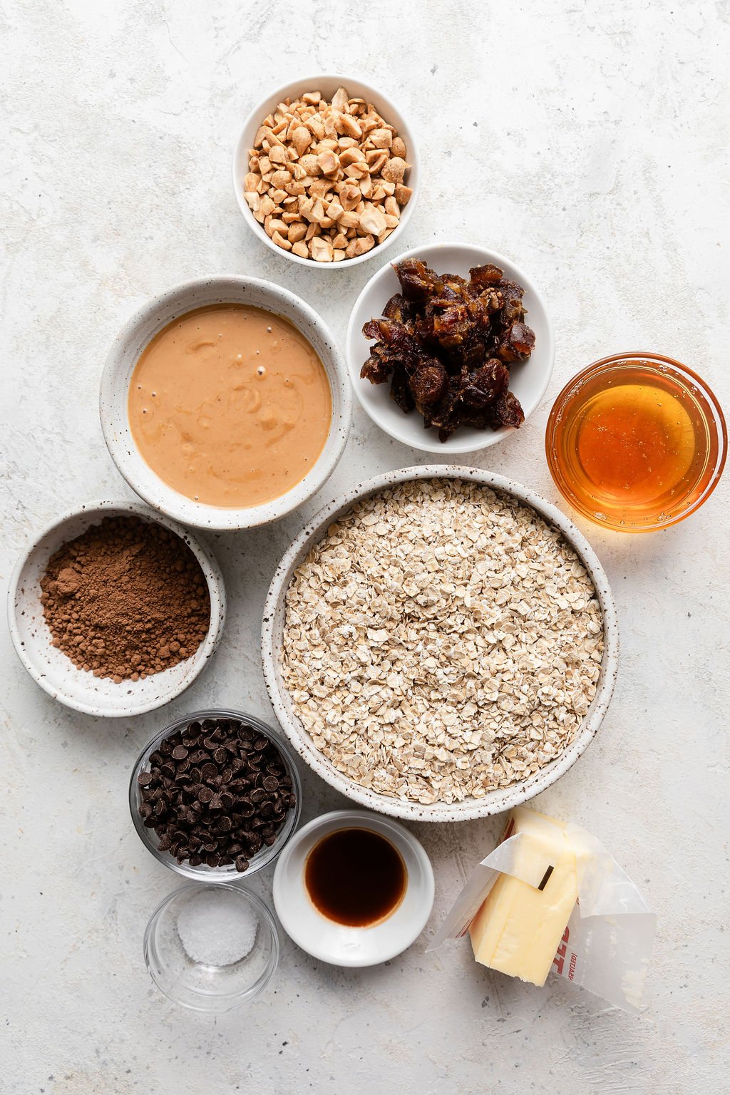 Overhead view of a variety of ingredients for No Bake Cookies in different sized bowls.