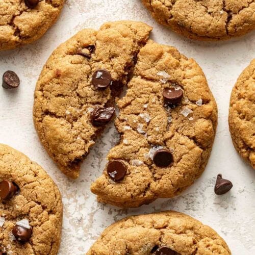 Overhead view of a freshly baked protein chocolate chip cookie broken in half to show the melted chocolate.