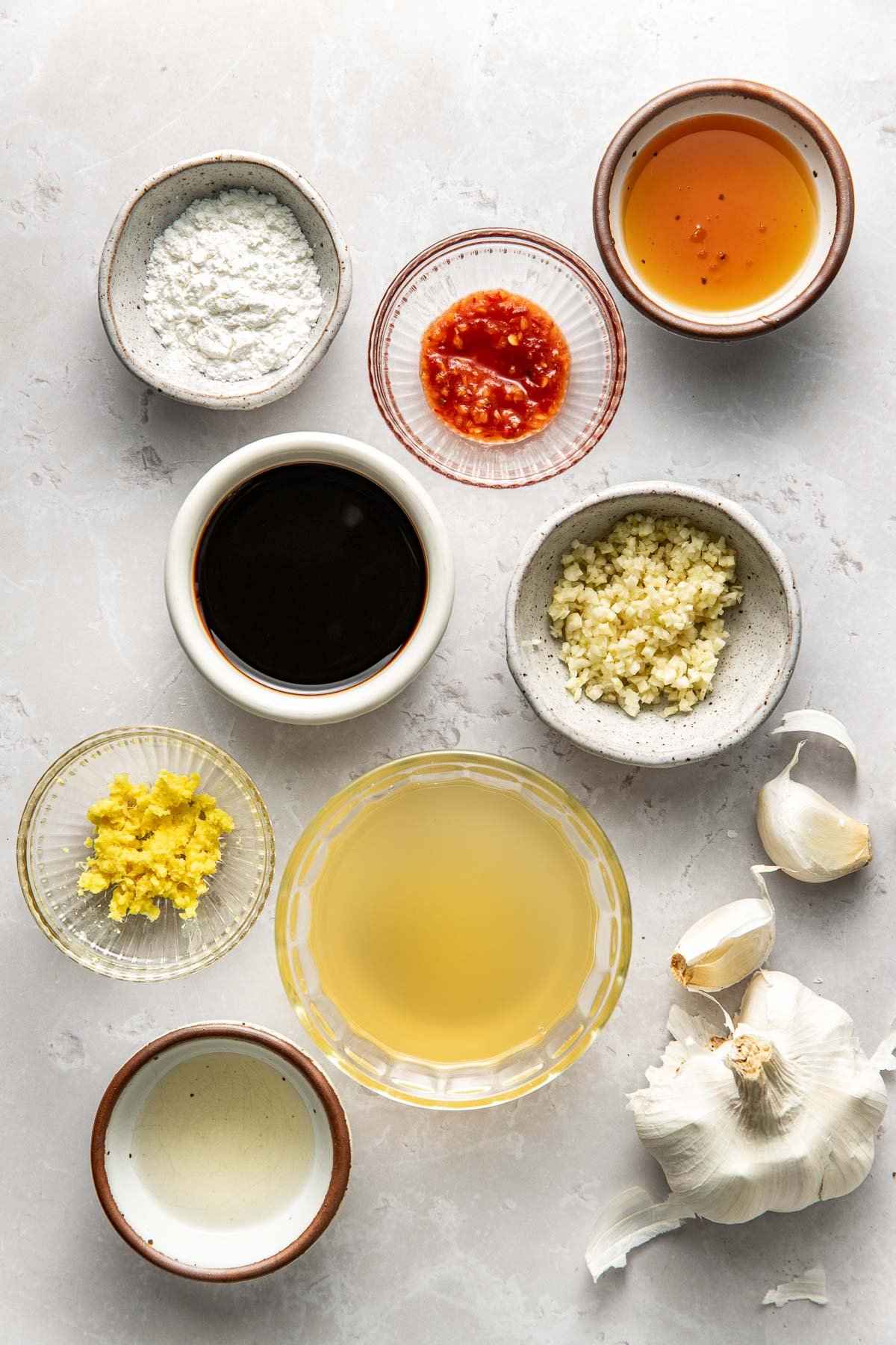 Overhead view of a variety of ingredients for Stir Fry Sauce in different sized bowls.