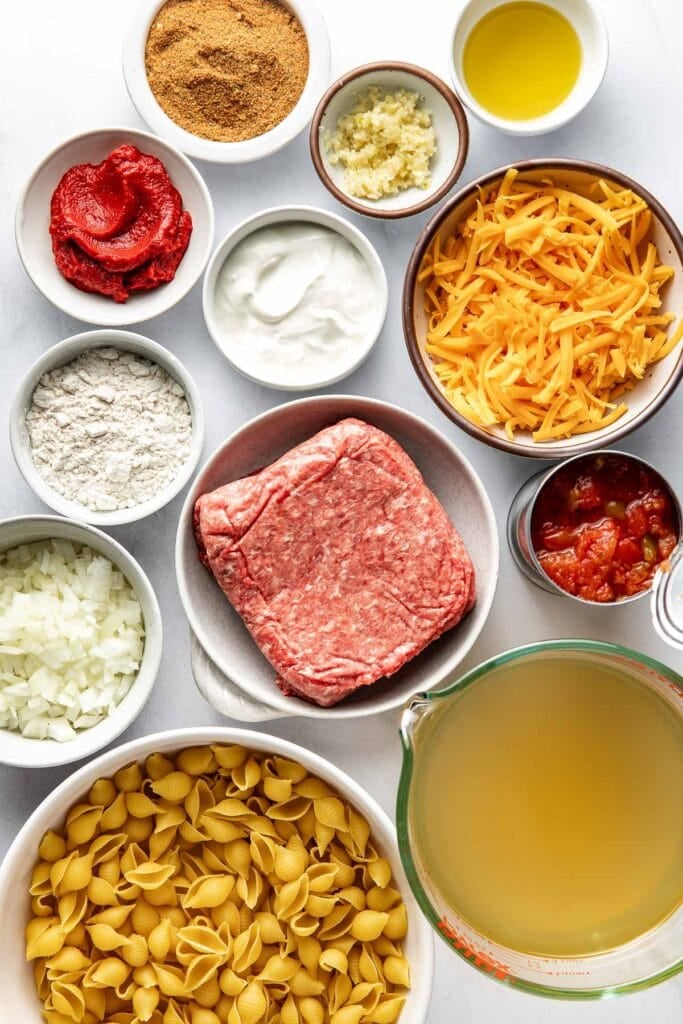 Overhead view of a variety of ingredients for Taco Pasta in different sized bowls.