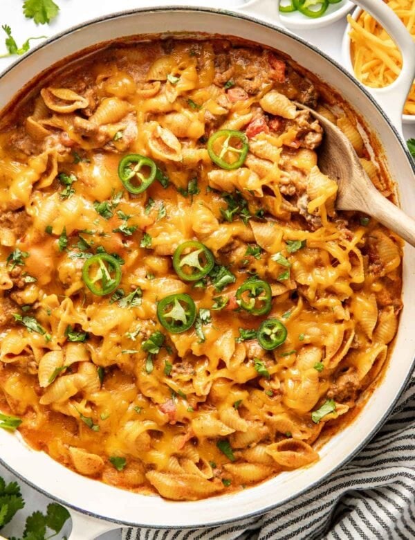 Overhead view of a white skillet filled with Taco Pasta topped with sliced jalapenos.