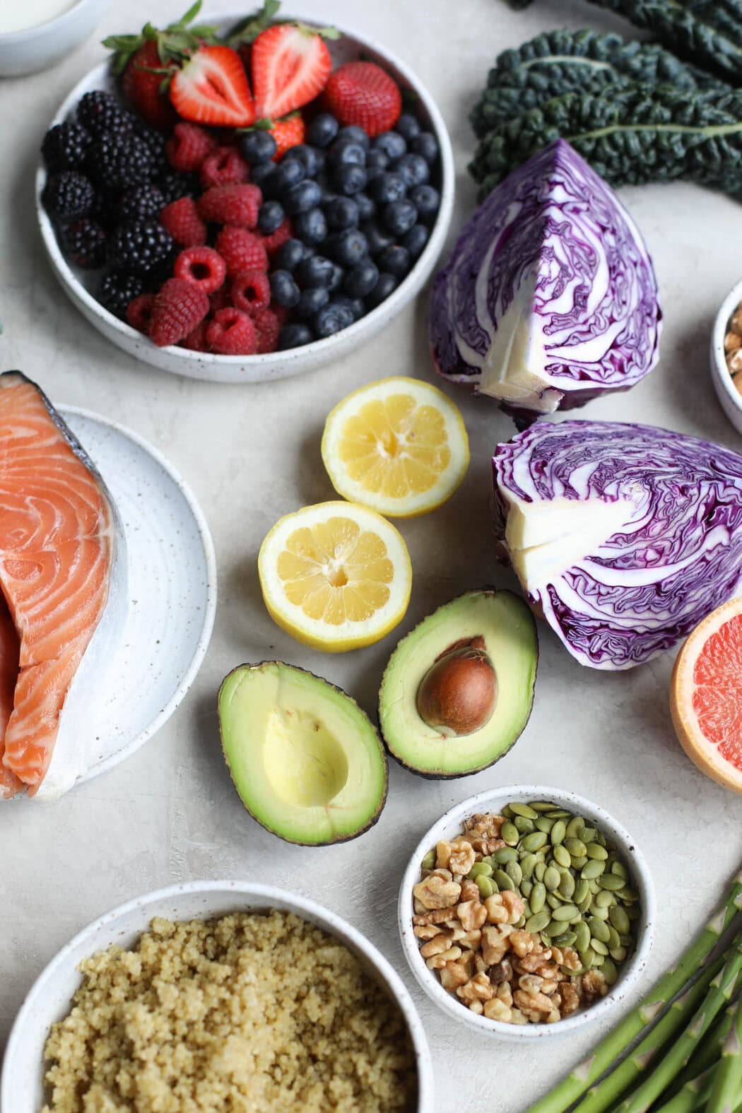 Overhead view of a variety of colorful fruits and vegetables on a marble countertop.