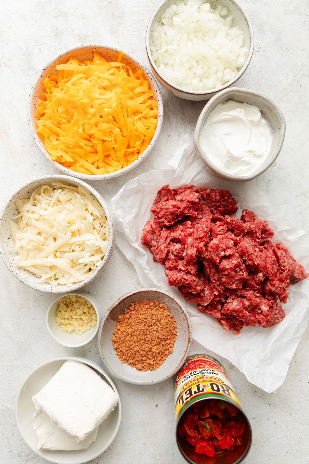Overhead view of a variety ingredients for Rotel Dip in different sized bowls.
