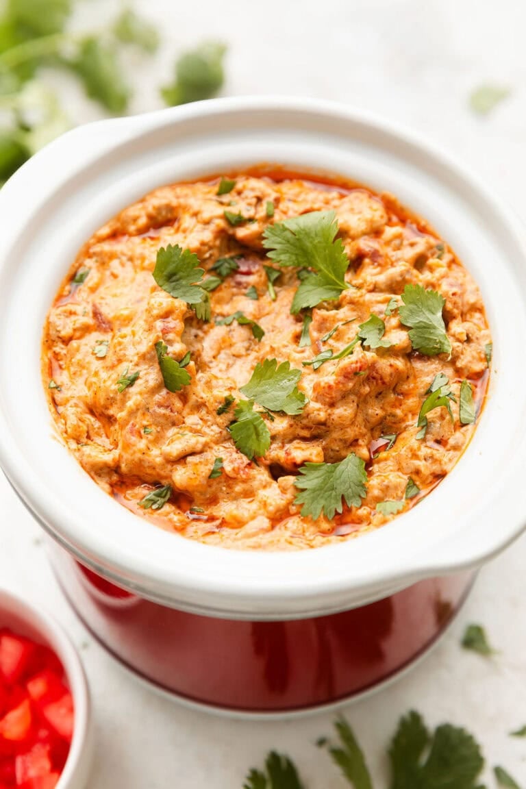 Overhead view of a slow cooker filled with Rotel Dip topped with fresh cilantro.