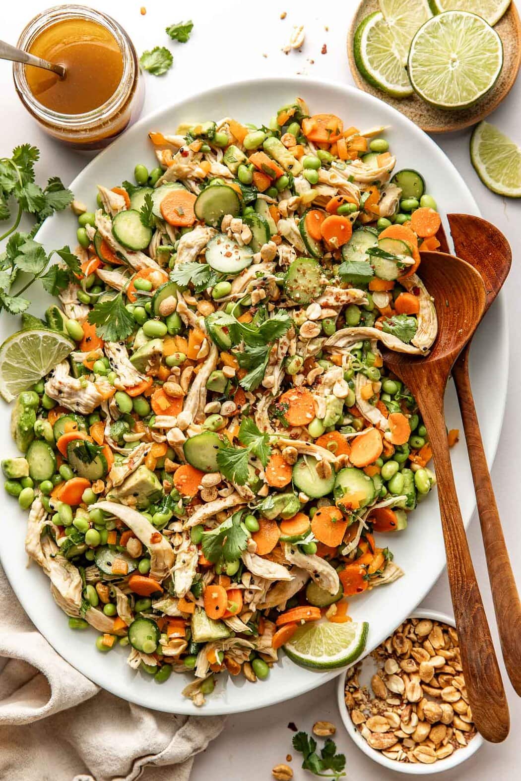 Overhead view of a white serving dish filled with Thai Chicken Salad with Edamame and fresh cilantro on top.