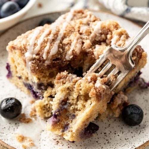 Overhead view of a piece of Blueberry Coffee Cake with a fork going into the side.