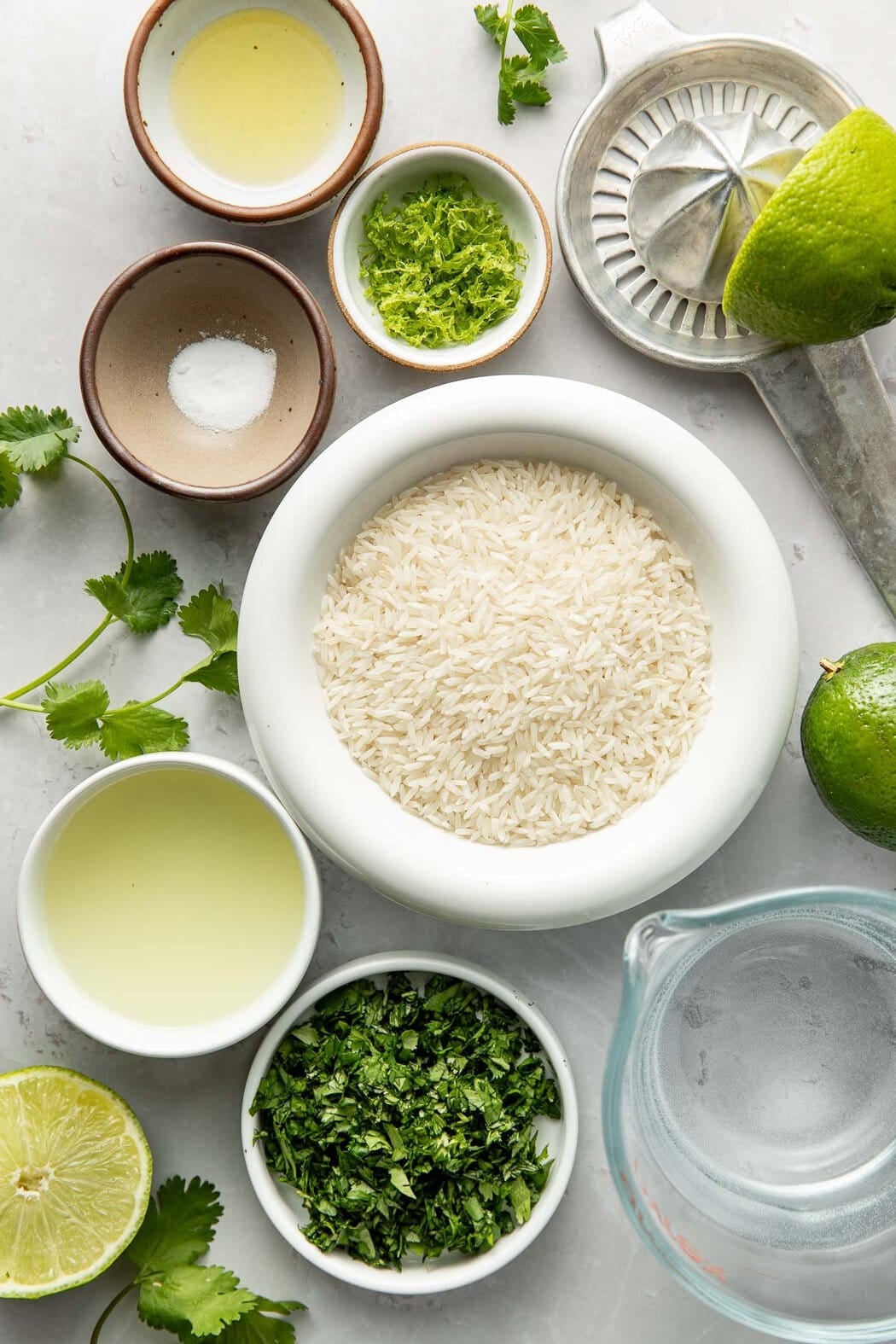 Overhead view of a variety of ingredients for Cilantro Lime Rice in different sized bowls.