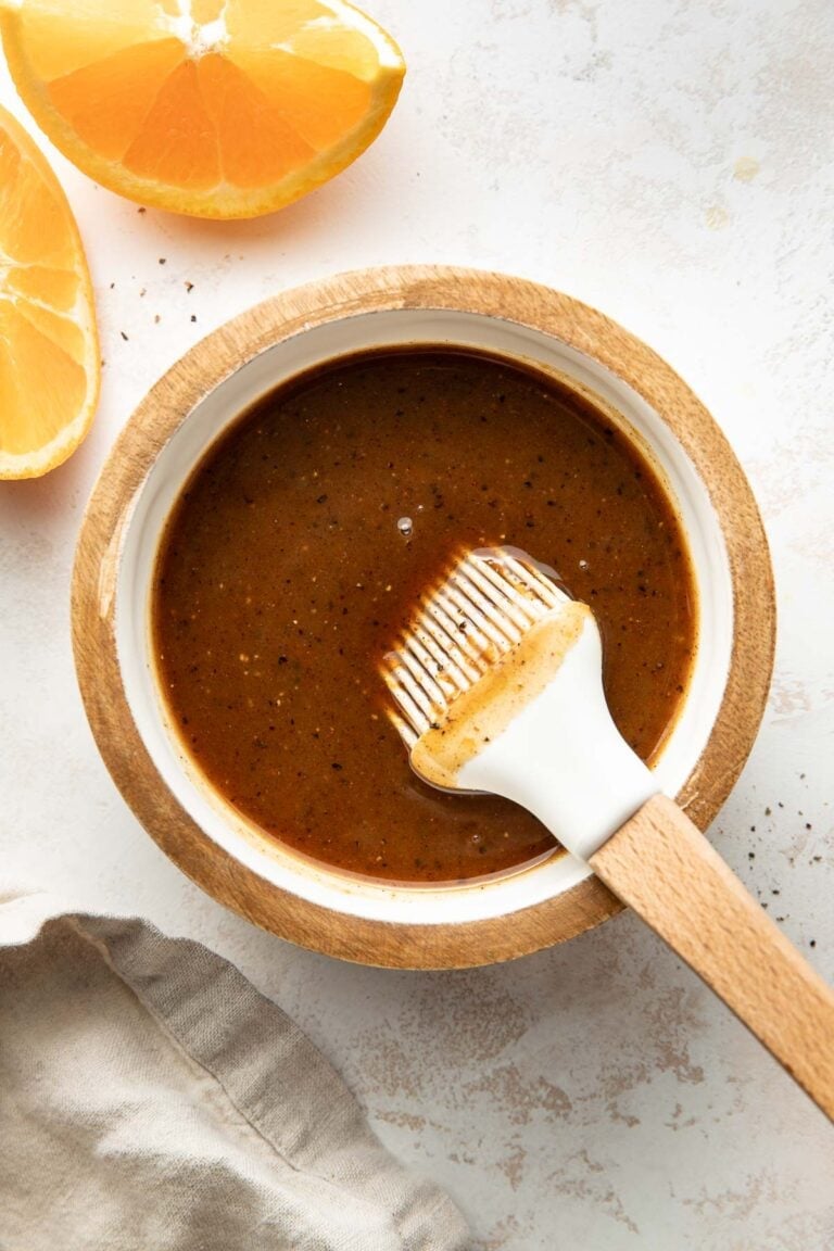 Overhead view of a small bowl filled with Ham Glaze with sliced oranges on the side of the dish.