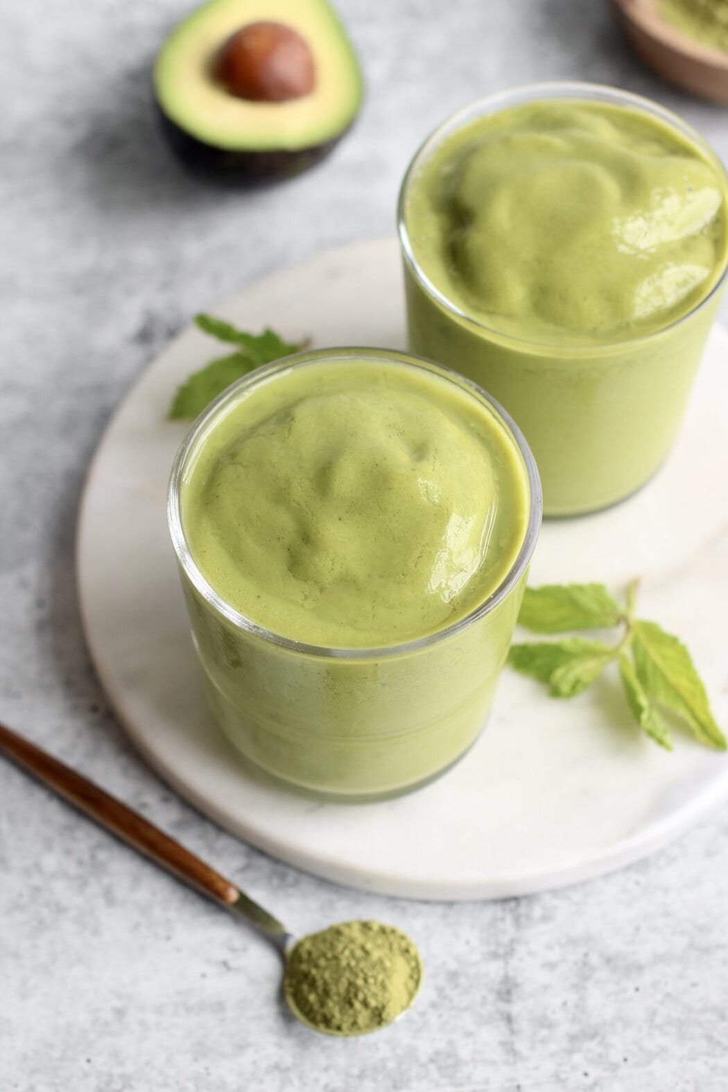 Overhead view of two glasses filled with matcha smoothies.