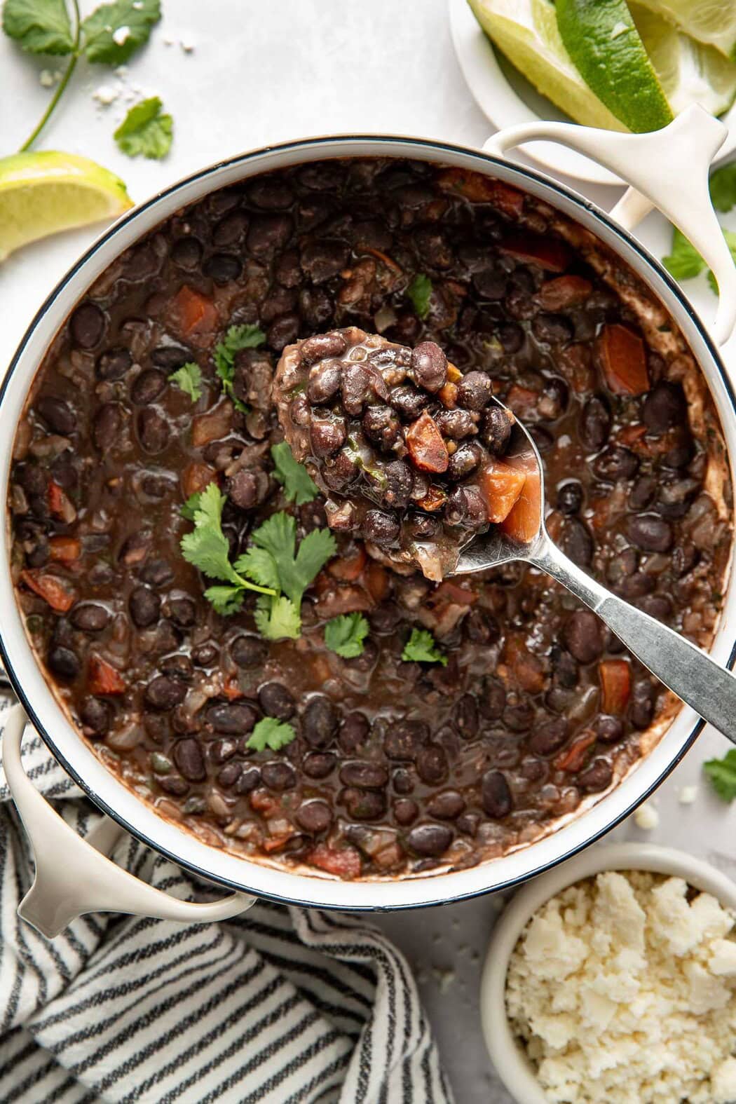 Overhead view of a skillet filled with Mexican Black Beans topped with fresh cilantro.