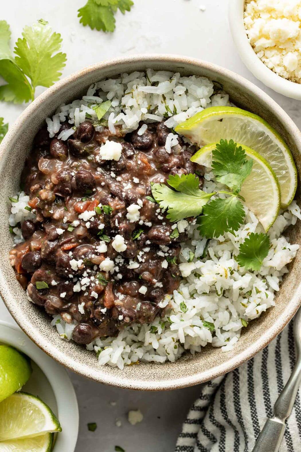 Overhead view of a bowl of cilantro lime rice topped with Mexican Black Beans and sprinkled with fresh cilantro.