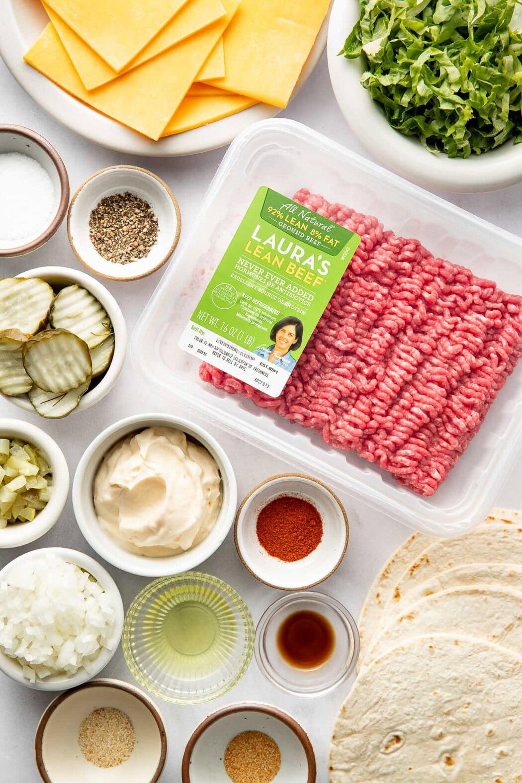 Overhead view of a variety of ingredients for Smash Burger Tacos in different sized bowls.