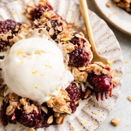 Overhead view of a plate filled with Blackberry Crumble topped with vanilla ice cream.