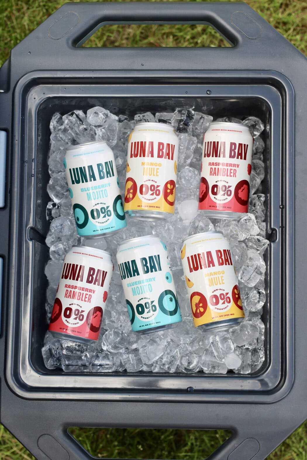 Overhead view of an open cooler of ice and canned Luna Bay mocktails.