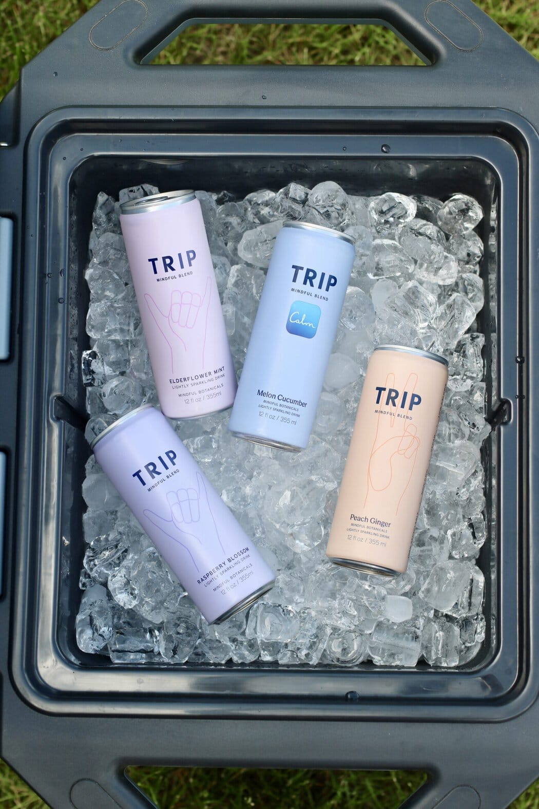 Overhead view of a cooler filled with ice and trip brand canned mocktails.