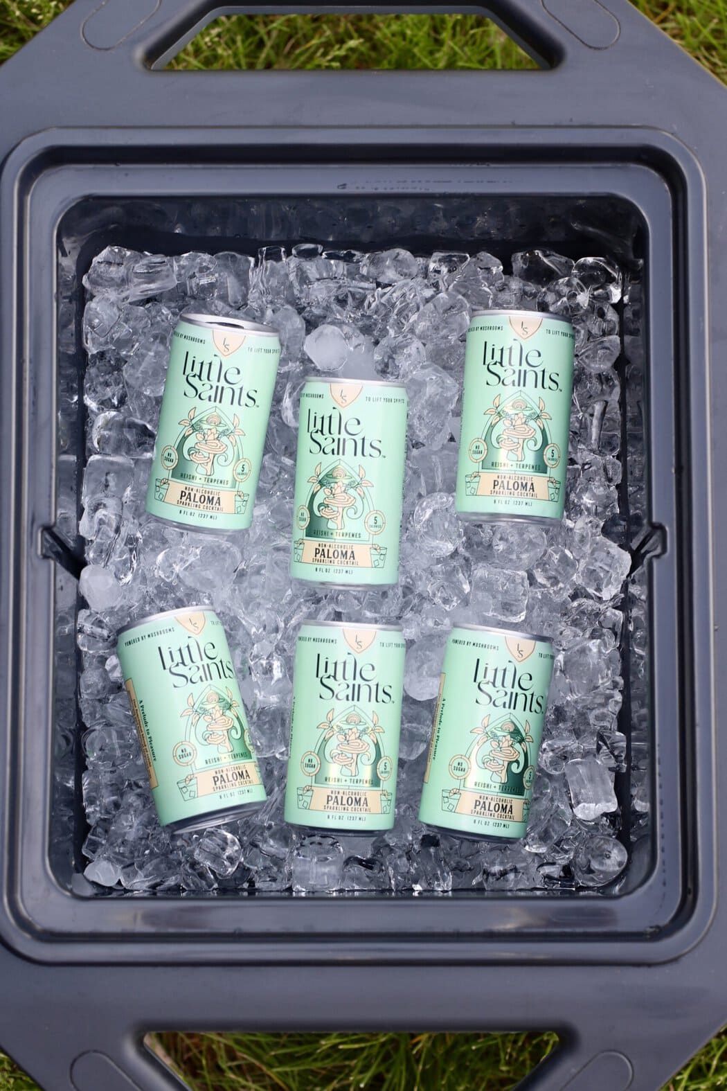 Overhead view of a cooler full of ice and little saints canned mocktails.