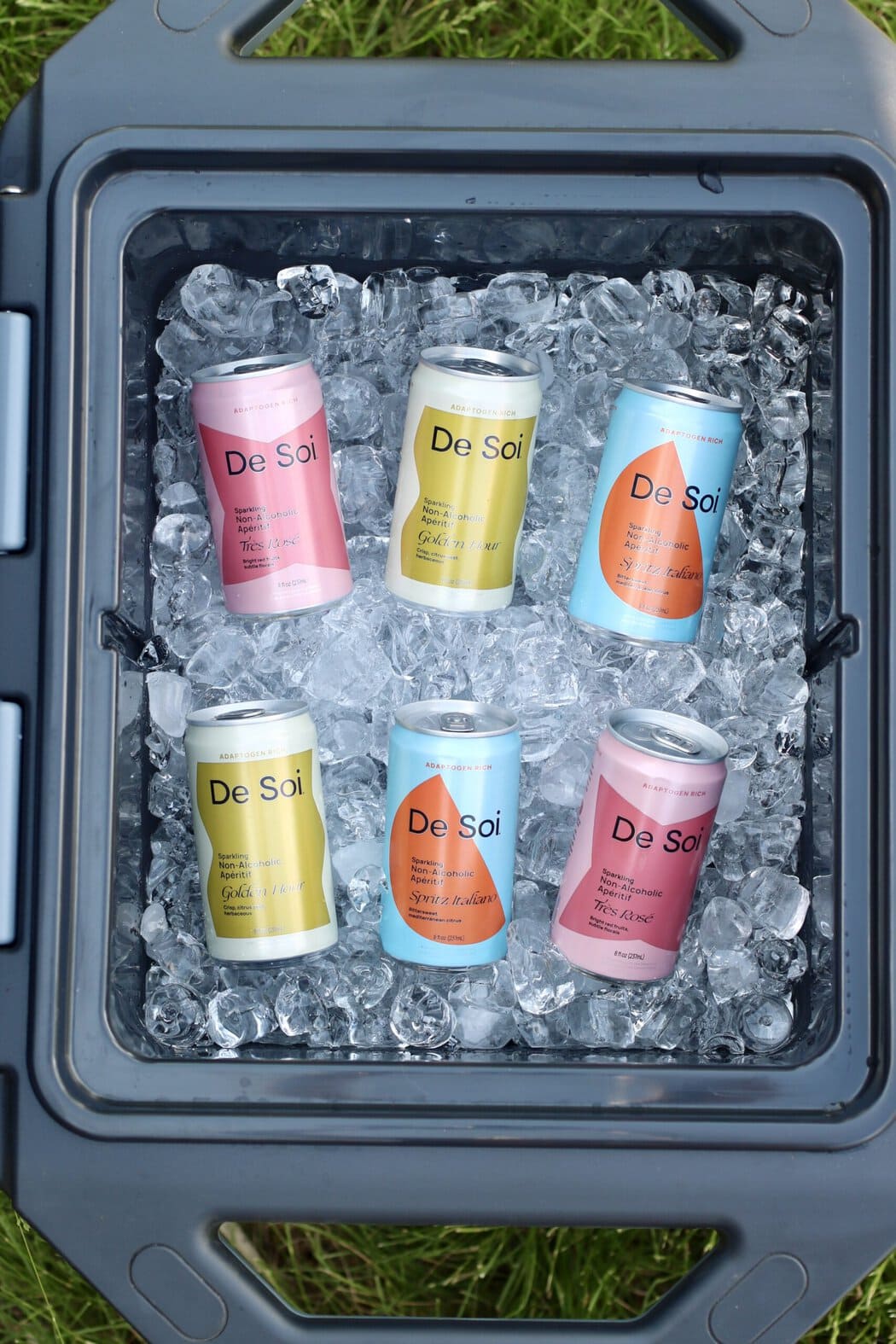 Overhead view of a cooler filled with ice and several De Soi canned mocktails.