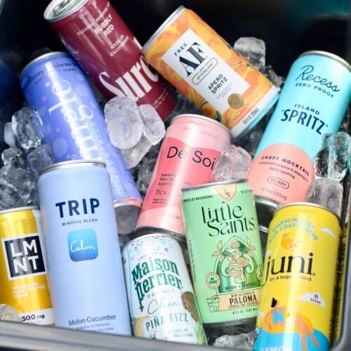Overhead view of a variety of canned mocktails in a cooler filled with ice.