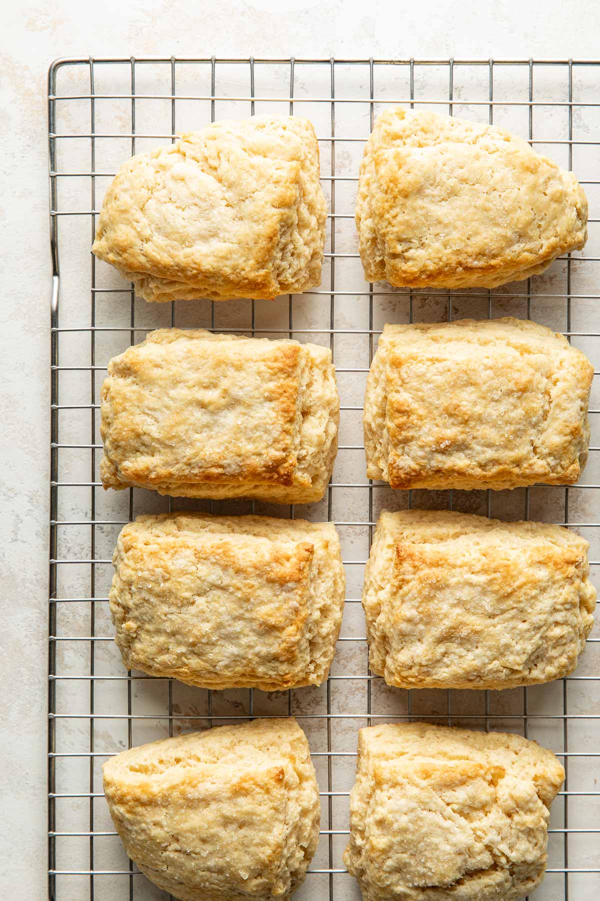 Close up view of freshly baked sweet cream biscuits on a wire cooling rack.