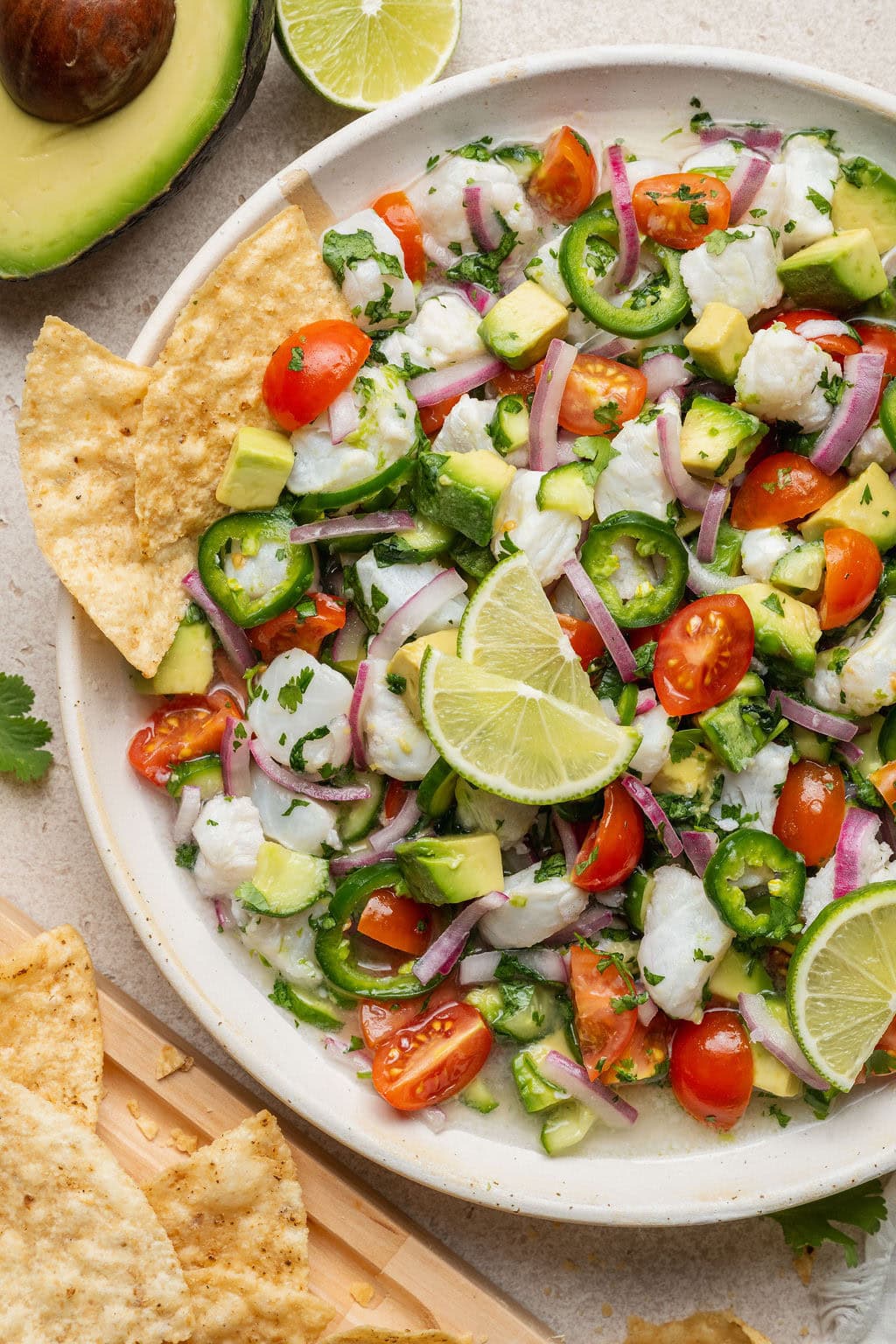 Close up view of a bowl of colorful fresh Ceviche with tortilla chips stuck into the side.