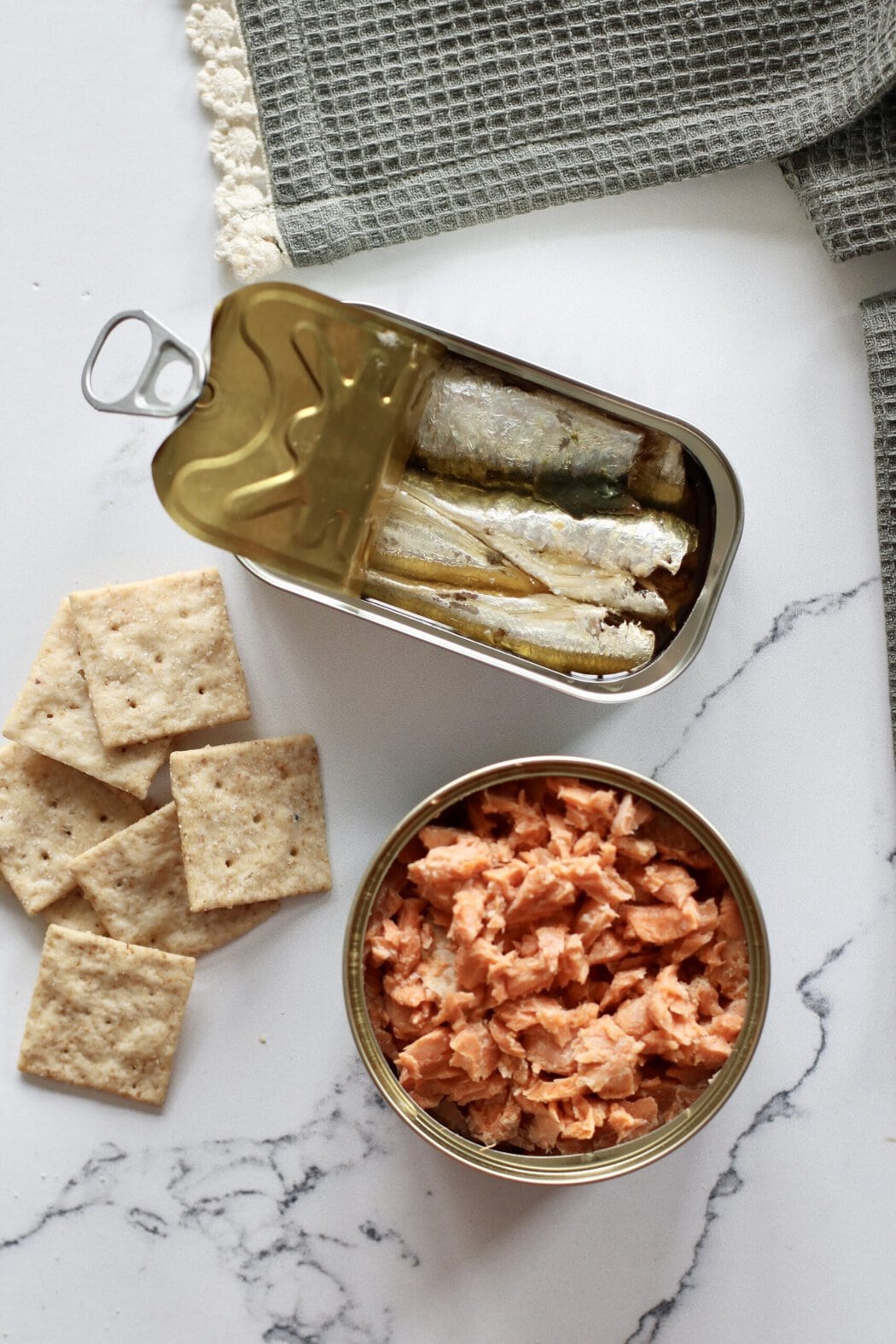 A can of sardines, a can of salmon, and crackers.