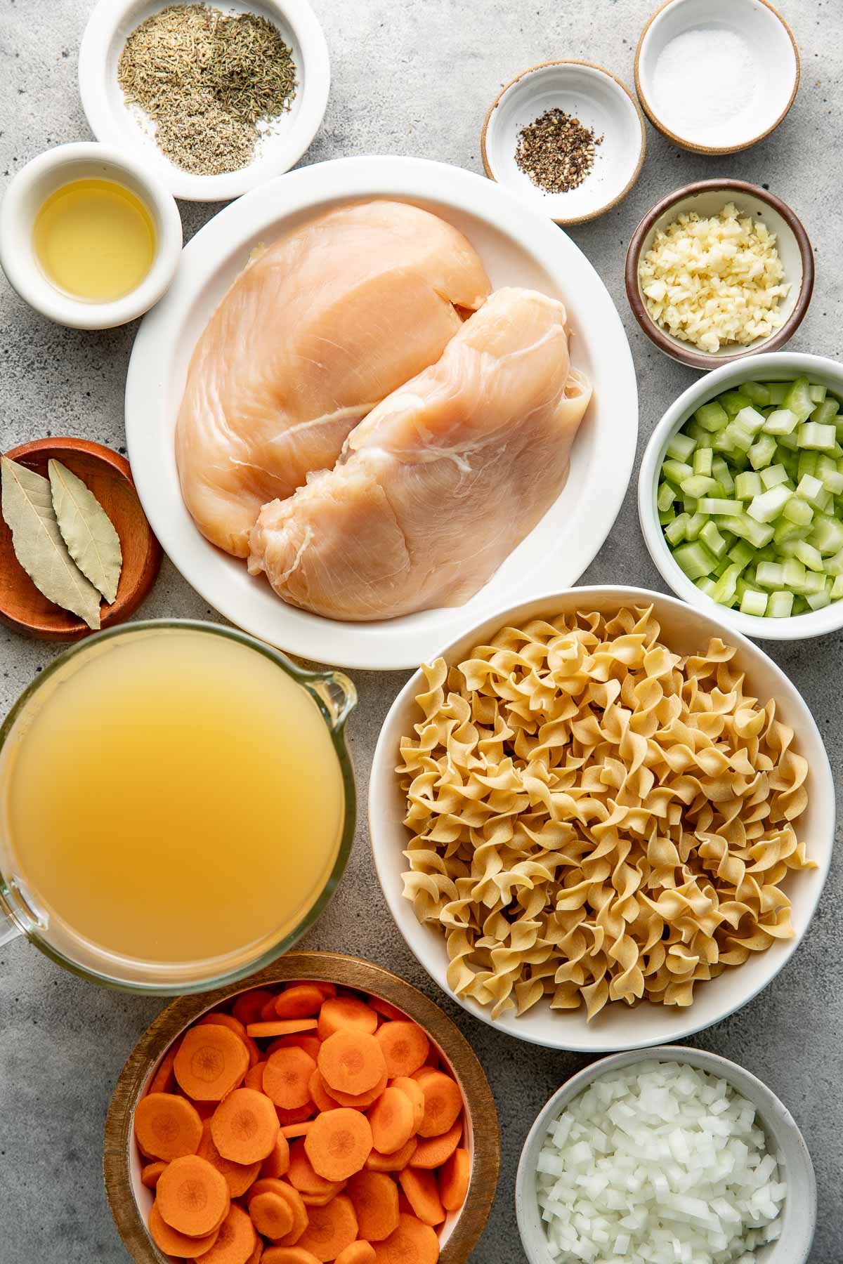 Ingredients to make homemade chicken noodle soup with chicken breasts.