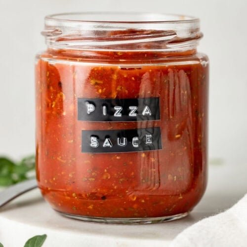 A glass jar of pizza sauce with a black label.