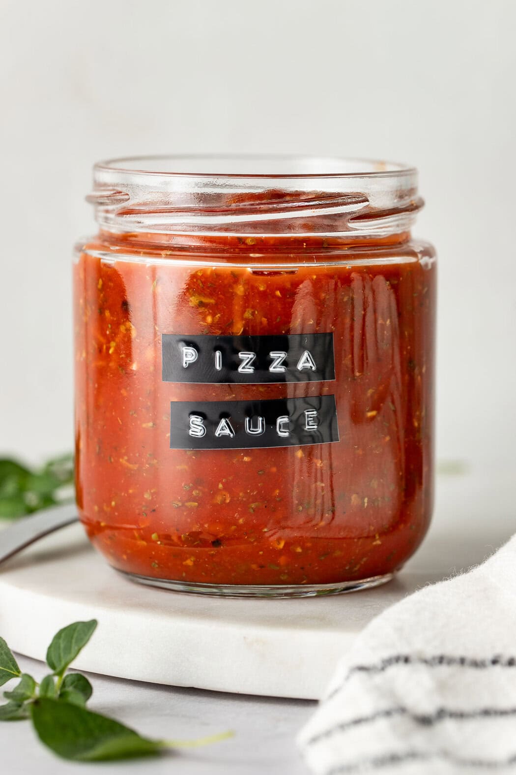 A glass jar of pizza sauce with a black label.