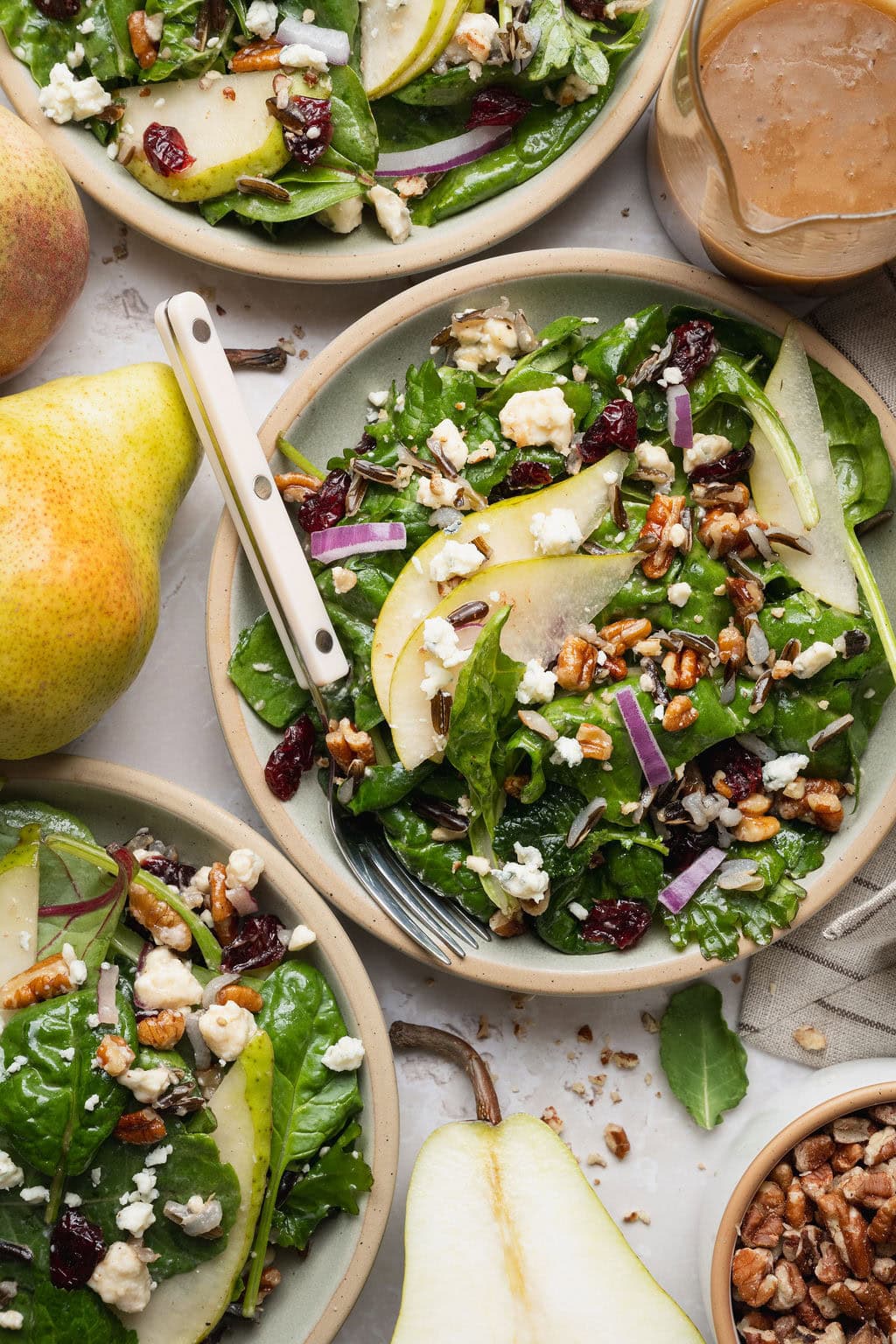 Pear salad on three plates, a fork on top of the center plate.
