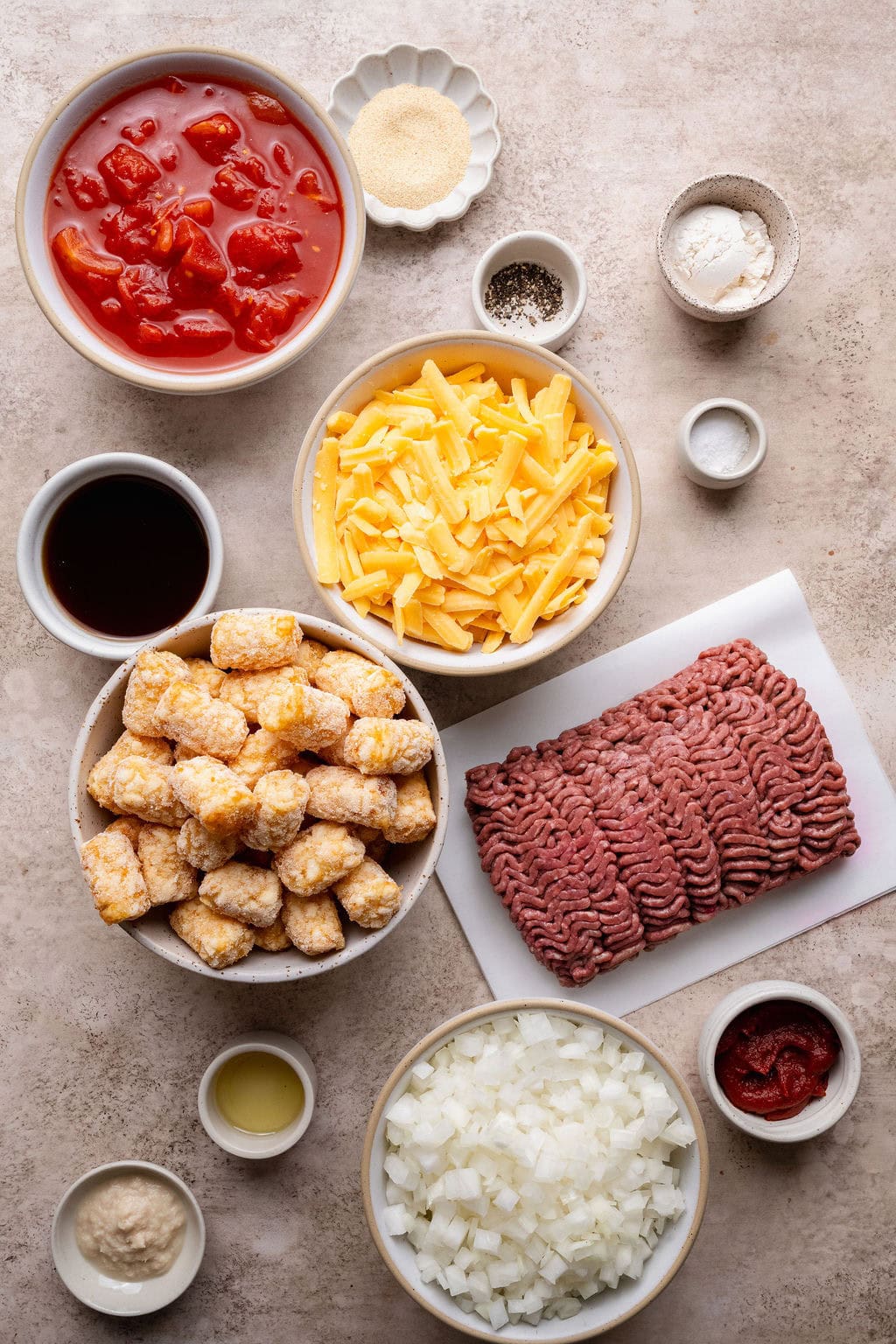 Ingredients to make cheeseburger casserole with ground beef and frozen tater tots.