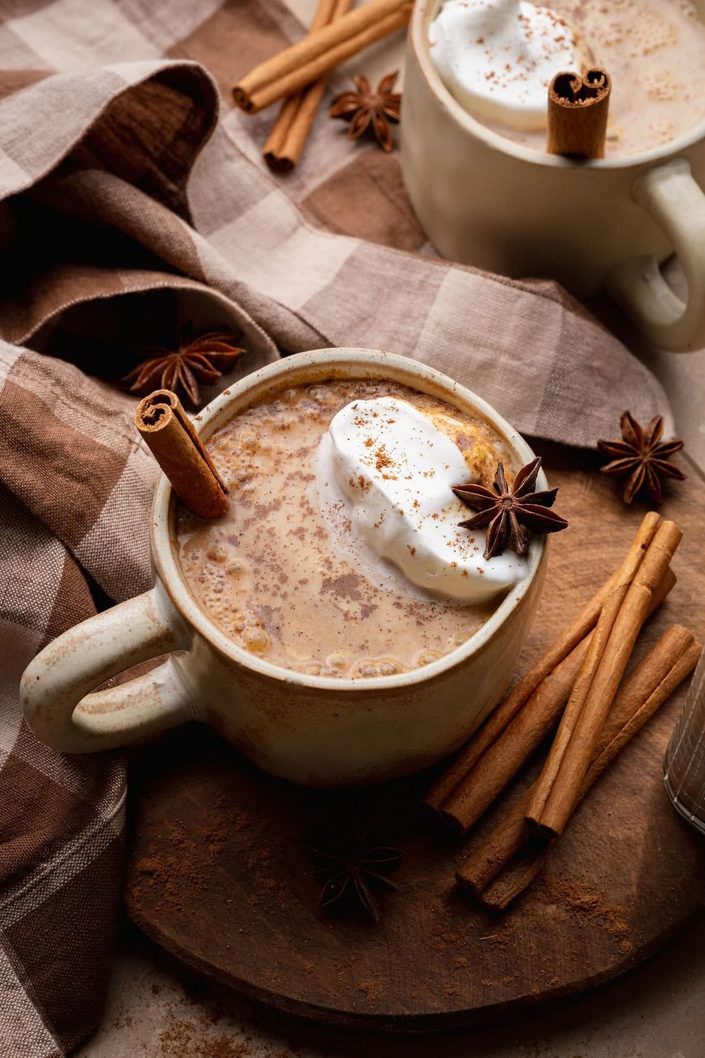 A pumpkin chai latte with a cinnamon stick sticking out.